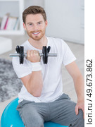 beautiful young adult training with dumbbell. Стоковое фото, агентство Ingram Publishing / Фотобанк Лори