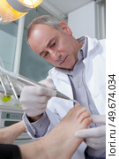 doctor removing something from the toenail. Стоковое фото, агентство Ingram Publishing / Фотобанк Лори