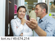 salesman in discussion with customer gesturing forwards. Стоковое фото, агентство Ingram Publishing / Фотобанк Лори