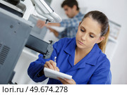 female technician doing maintenance on servers with a clipboard. Стоковое фото, агентство Ingram Publishing / Фотобанк Лори