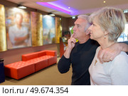 senior couple choosing a film to watch in a cinema. Стоковое фото, агентство Ingram Publishing / Фотобанк Лори