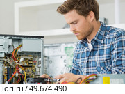 handsome computer engineer repairing a faulty pc. Стоковое фото, агентство Ingram Publishing / Фотобанк Лори