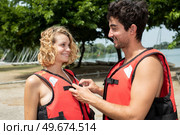 boyfriend helping his girlfriend button her safety jacket. Стоковое фото, агентство Ingram Publishing / Фотобанк Лори
