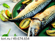 Whole tasty mackerel fish grilled with kiwi fruits.. Baked fish, grilled mackerel. Стоковое фото, агентство Ingram Publishing / Фотобанк Лори