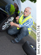 retired man has to change punctured wheel. Стоковое фото, агентство Ingram Publishing / Фотобанк Лори