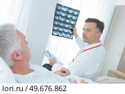 doctor showing xray to a senior patient in hospital. Стоковое фото, агентство Ingram Publishing / Фотобанк Лори