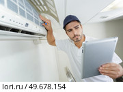 young contractor working carefully and seriously at clients office. Стоковое фото, агентство Ingram Publishing / Фотобанк Лори