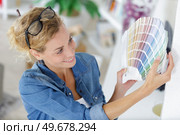 womans hands chosen color from color swatches book. Стоковое фото, агентство Ingram Publishing / Фотобанк Лори