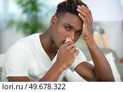 young man with tissue in his nostril. Стоковое фото, агентство Ingram Publishing / Фотобанк Лори