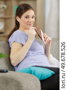 young pregnant woman holding chocolate bar. Стоковое фото, агентство Ingram Publishing / Фотобанк Лори