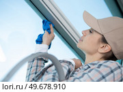 female worker cleaning window rag and spray. Стоковое фото, агентство Ingram Publishing / Фотобанк Лори