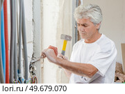 Chiseling away at a wall. Стоковое фото, агентство Ingram Publishing / Фотобанк Лори