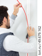 electrician making wiring at new house. Стоковое фото, агентство Ingram Publishing / Фотобанк Лори
