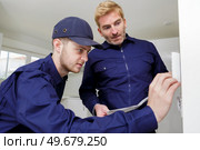 installing a programmable room thermostat. Стоковое фото, агентство Ingram Publishing / Фотобанк Лори
