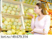 Lady smelling a melon for ripeness. Стоковое фото, агентство Ingram Publishing / Фотобанк Лори