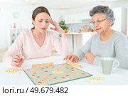 old lady in geriatric hospice playing with assistant. Стоковое фото, агентство Ingram Publishing / Фотобанк Лори
