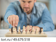 man making a move in a game of chesse. Стоковое фото, агентство Ingram Publishing / Фотобанк Лори