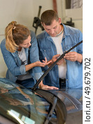 female and male worker picking up windscreen wiper. Стоковое фото, агентство Ingram Publishing / Фотобанк Лори