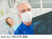 Dentist checking x-ray before drilling. Стоковое фото, агентство Ingram Publishing / Фотобанк Лори