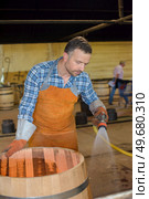Cooper spraying water on barrell. Стоковое фото, агентство Ingram Publishing / Фотобанк Лори