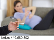 man smoking near upset pregnant woman at home. Стоковое фото, агентство Ingram Publishing / Фотобанк Лори
