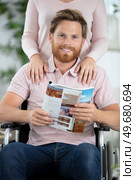 enthusiastic handicapped man is reading a magazine. Стоковое фото, агентство Ingram Publishing / Фотобанк Лори