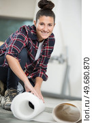 a female worker unrolling carpet. Стоковое фото, агентство Ingram Publishing / Фотобанк Лори