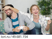 woman closing mans eyes while playing video games. Стоковое фото, агентство Ingram Publishing / Фотобанк Лори