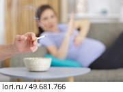 young pregnant women raise her hand against smoke. Стоковое фото, агентство Ingram Publishing / Фотобанк Лори