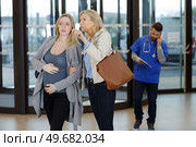 pregnant woman in hospital lobby being given directions. Стоковое фото, агентство Ingram Publishing / Фотобанк Лори