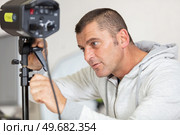 photographer controlling the studio flash strobe lighting head. Стоковое фото, агентство Ingram Publishing / Фотобанк Лори