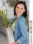 beautiful woman holds vase of arum lilies. Стоковое фото, агентство Ingram Publishing / Фотобанк Лори