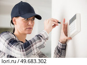 a woman working on thermostat. Стоковое фото, агентство Ingram Publishing / Фотобанк Лори