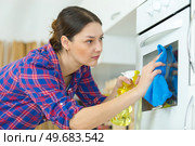 woman in protective gloves cleaning oven. Стоковое фото, агентство Ingram Publishing / Фотобанк Лори