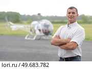 portrait of man at airfield helicopter in background. Стоковое фото, агентство Ingram Publishing / Фотобанк Лори
