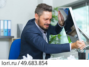 angry man hitting the computer screen. Стоковое фото, агентство Ingram Publishing / Фотобанк Лори