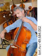 portait of cellist testing the cello. Стоковое фото, агентство Ingram Publishing / Фотобанк Лори