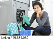worried young housewife next to washing machine. Стоковое фото, агентство Ingram Publishing / Фотобанк Лори