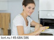 a woman cleaning an oven. Стоковое фото, агентство Ingram Publishing / Фотобанк Лори