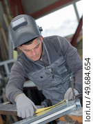 welder man measuring part in the workshop. Стоковое фото, агентство Ingram Publishing / Фотобанк Лори