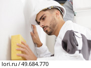 a man cleaning wall surface. Стоковое фото, агентство Ingram Publishing / Фотобанк Лори