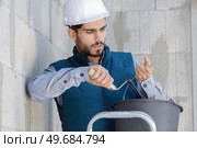 builder plastering grey concrete wall. Стоковое фото, агентство Ingram Publishing / Фотобанк Лори