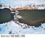 Waterfall on winter creek. Snow on frozen riverbanks. Top Aerial View Of River Cascade. Stream water flowing between rocks. Europe. Стоковое фото, агентство Ingram Publishing / Фотобанк Лори