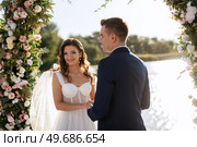 wedding ceremony on a high pier near the river with invited guests. Стоковое фото, агентство Ingram Publishing / Фотобанк Лори
