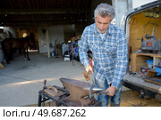 a man blacksmith shaping horseshoe. Стоковое фото, агентство Ingram Publishing / Фотобанк Лори