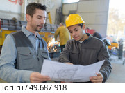 male factory worker and supervisor are analyzing plans. Стоковое фото, агентство Ingram Publishing / Фотобанк Лори