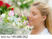a woman is smelling flowers. Стоковое фото, агентство Ingram Publishing / Фотобанк Лори