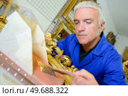 a mature male goldsmith making ornamental picture frames. Стоковое фото, агентство Ingram Publishing / Фотобанк Лори