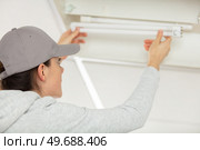 woman changing light neon bulb. Стоковое фото, агентство Ingram Publishing / Фотобанк Лори
