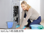 mature woman mopping up leaking machine. Стоковое фото, агентство Ingram Publishing / Фотобанк Лори